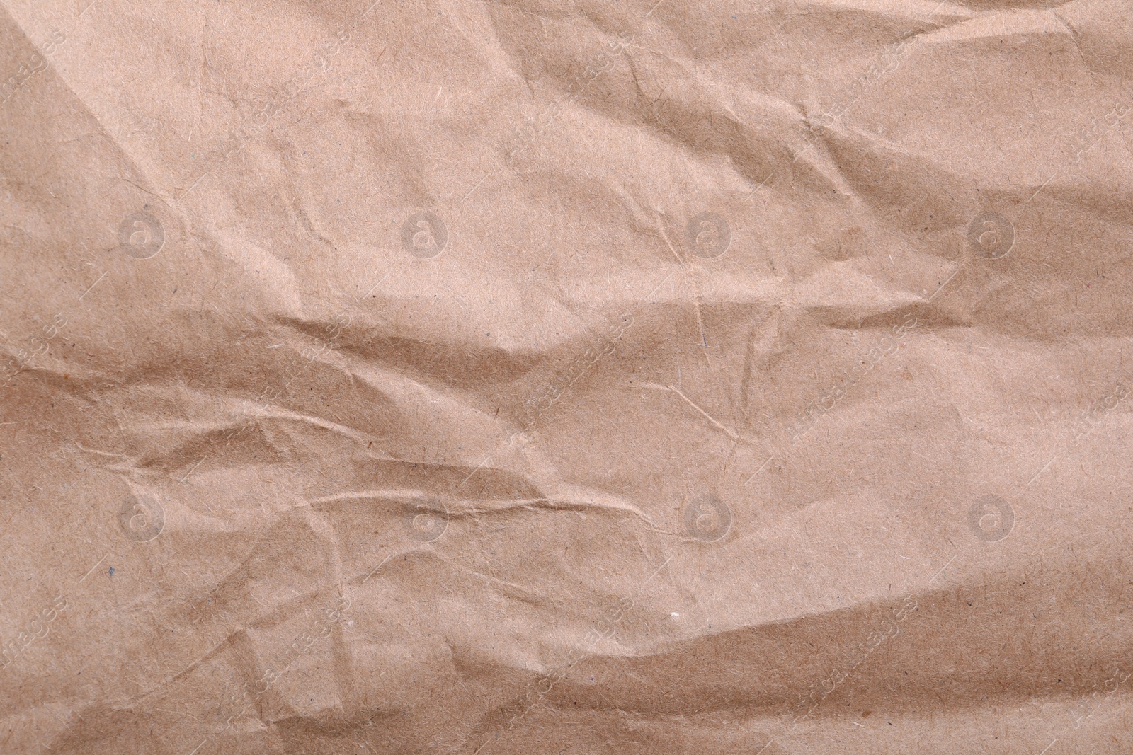 Photo of Texture of wrinkled kraft paper bag as background, closeup