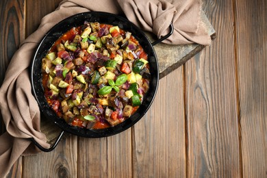 Delicious ratatouille in baking dish on wooden table, top view. Space for text