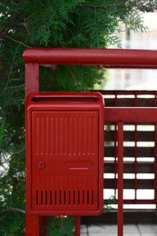 Photo of Red beautiful metal letter box near tree outdoors
