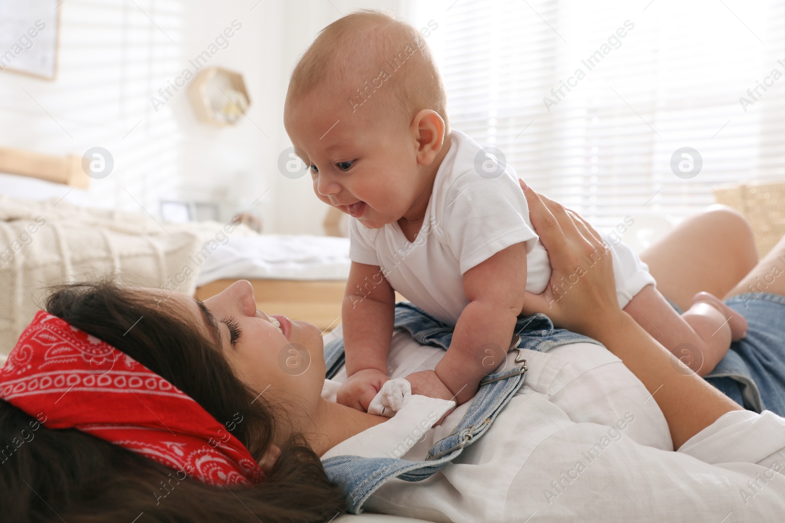 Photo of Young mother with her cute baby on floor at home