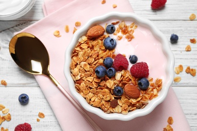 Tasty homemade granola served on white wooden table, flat lay. Healthy breakfast