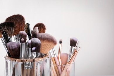 Photo of Set of professional makeup brushes on white background, closeup. Space for text