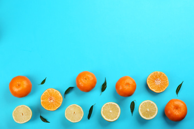 Flat lay composition with tangerines and lemons on blue background. Space for text