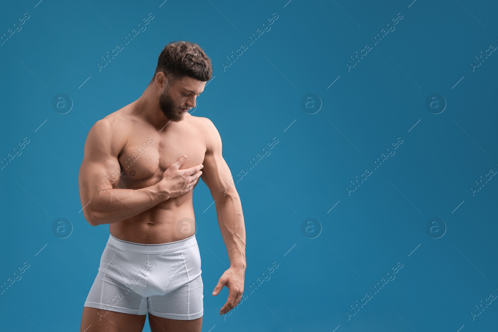 Photo of Handsome muscular man on light blue background, space for text. Sexy body