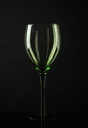 Elegant empty colorful wine glass on black background