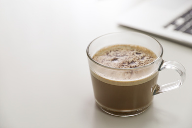 Cup of hot coffee on white table indoors in morning. Space for text