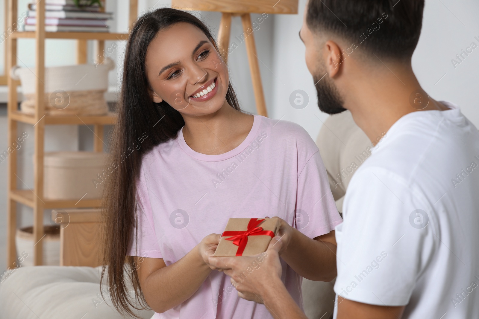 Photo of Lovely couple with beautiful gift at home