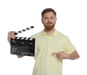 Making movie. Man pointing at clapperboard on white background