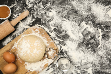 Photo of Flat lay composition with eggs and other ingredients on black table, space for text. Baking pie