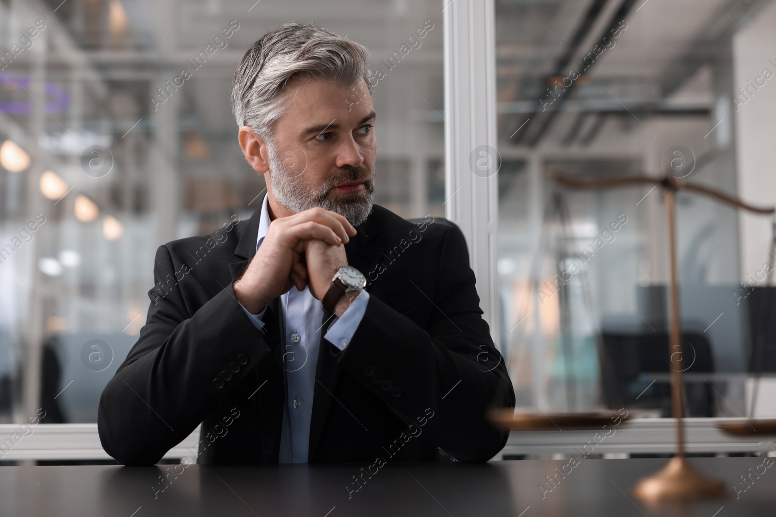 Photo of Portrait of confident lawyer at table in office