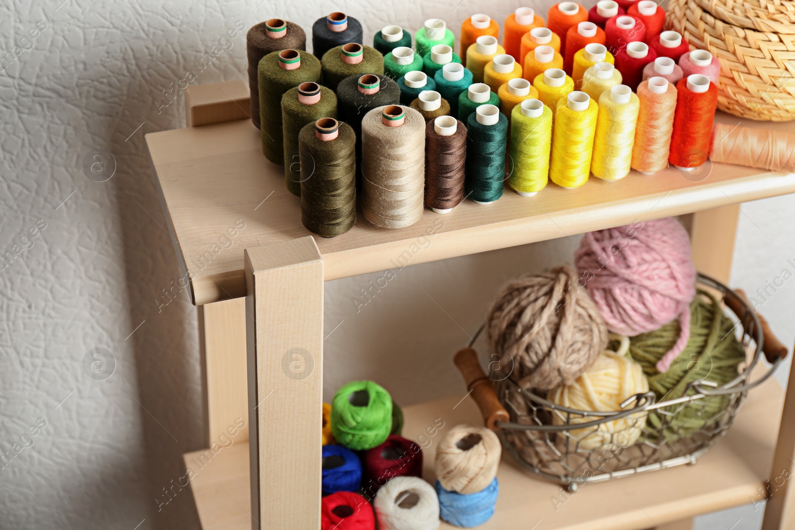 Photo of Set of color threads on wooden shelves