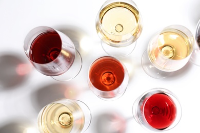 Different glasses with wine on white background, top view