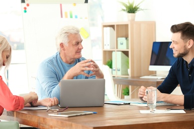 Photo of Group of people discussing ideas at table in office. Consulting service concept