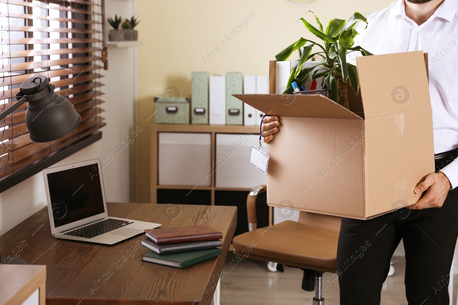 Photo of Businessman with moving box in office, closeup. Work promotion concept