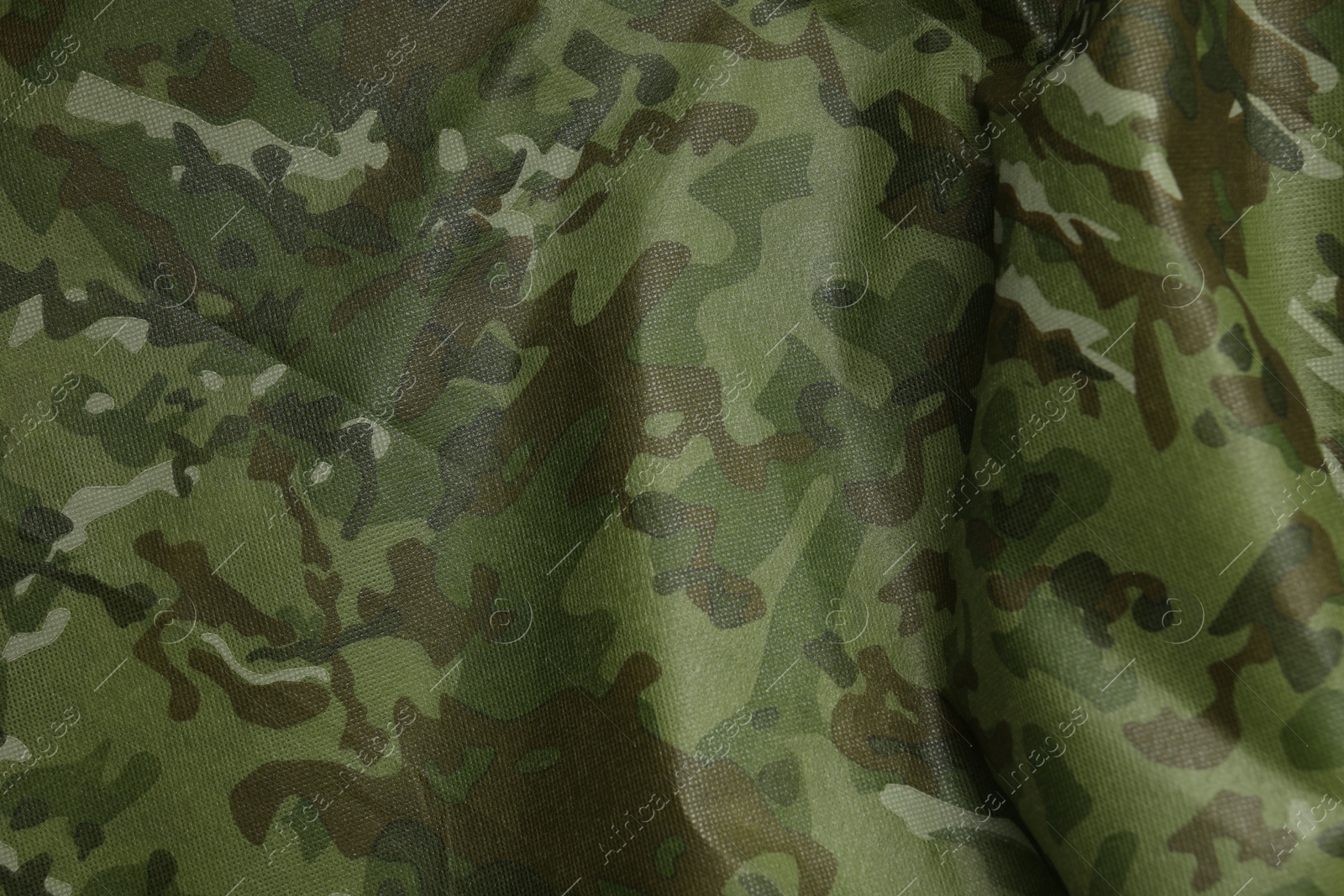 Photo of Texture of crumpled camouflage fabric as background, top view