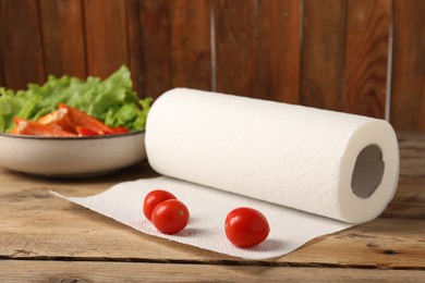 Photo of Fresh vegetables and roll of paper towels on wooden table