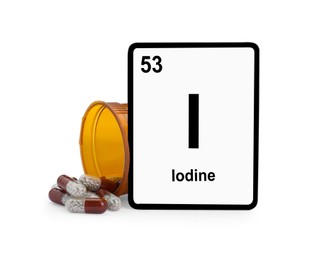 Photo of Card with iodine element, jar and pills isolated on white