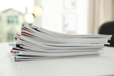 Stack of documents with paper clips on office table