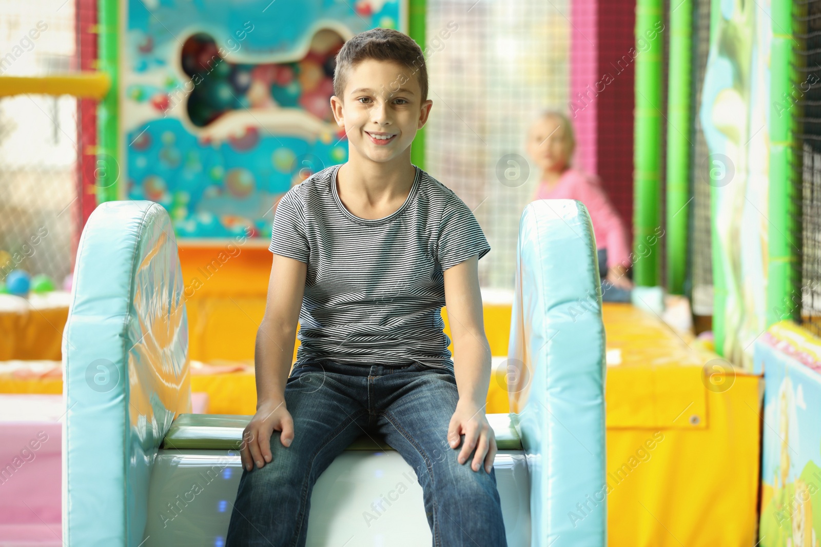 Photo of Cute little child playing at indoor amusement park