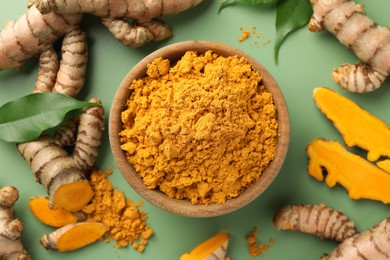 Photo of Aromatic turmeric powder, raw roots and leaves on green background, flat lay