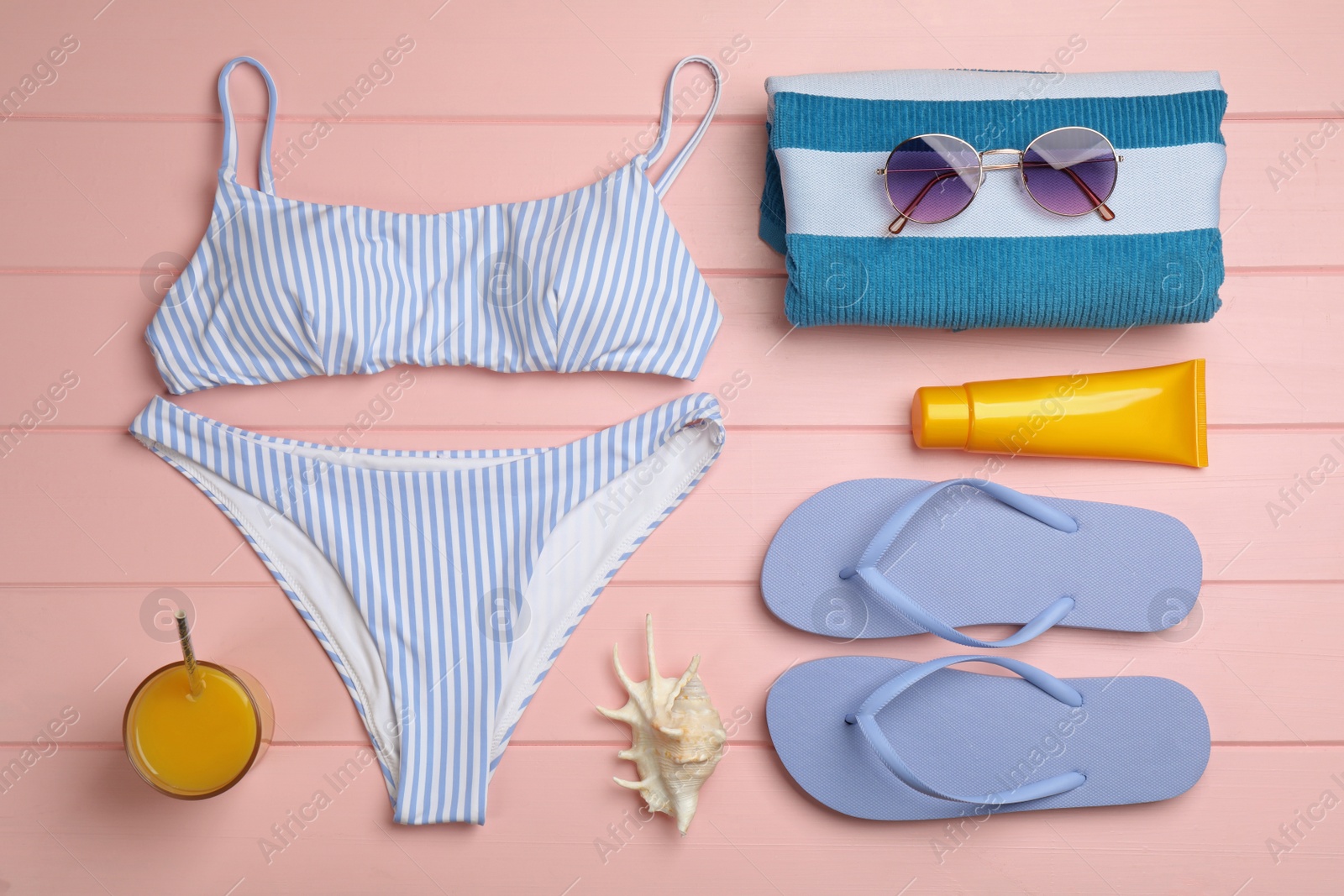 Photo of Flat lay composition with beach objects on pink wooden background