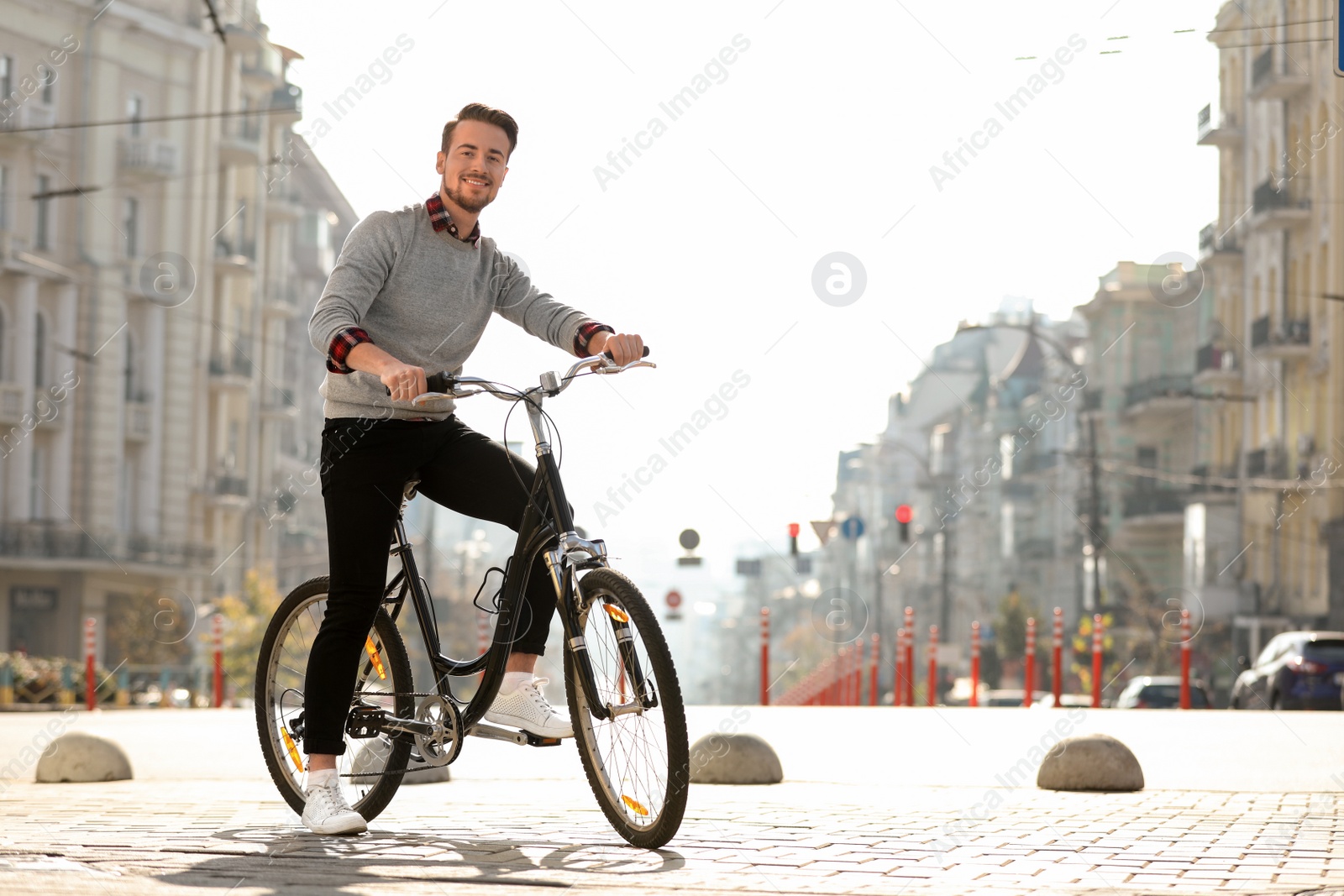 Photo of Handsome happy man riding bicycle on city street