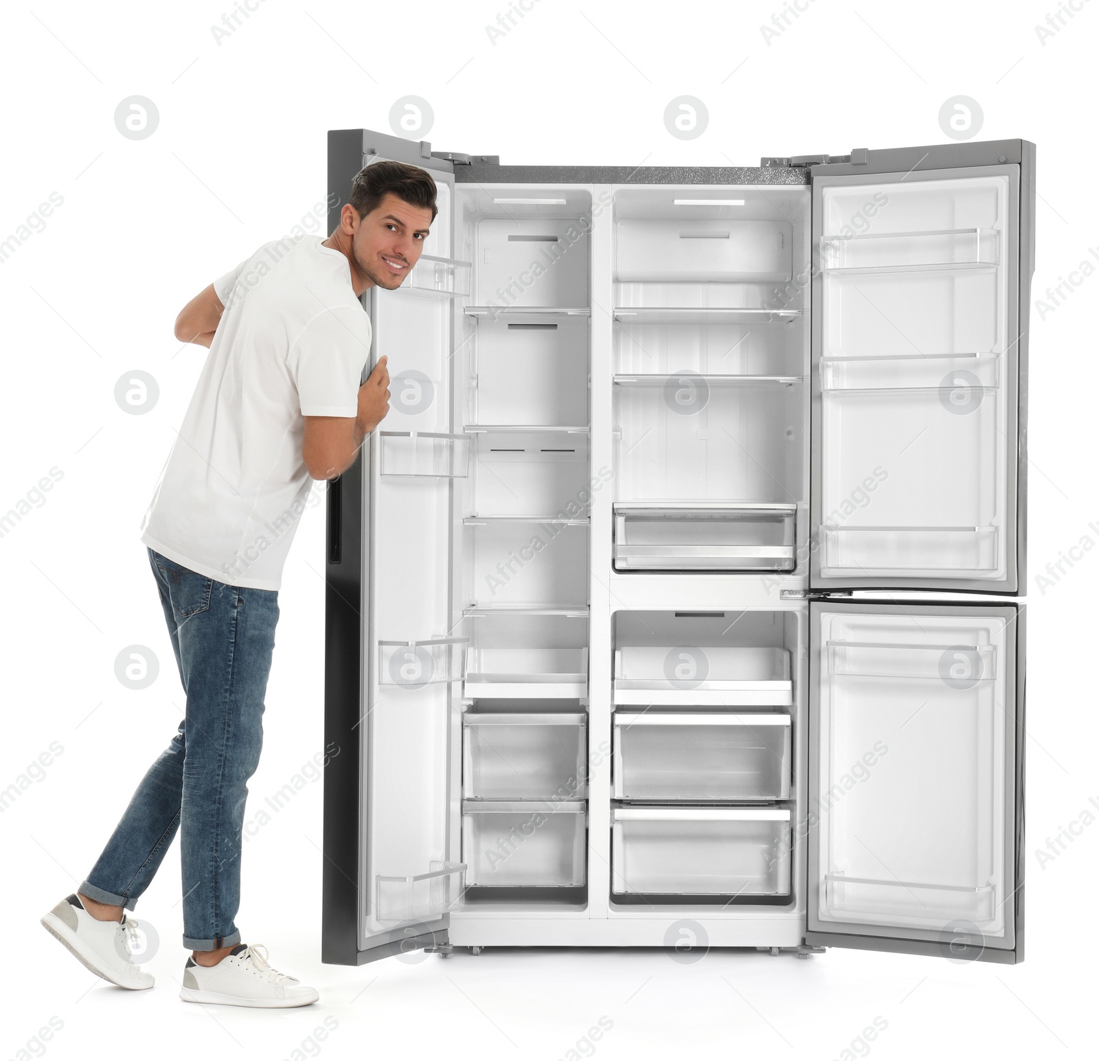 Photo of Man near open empty refrigerator on white background