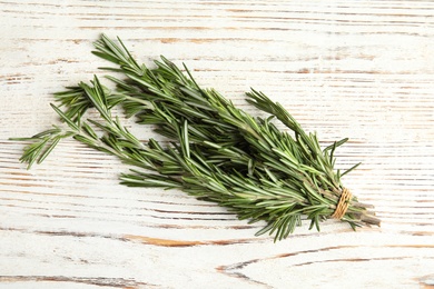 Photo of Bunch of fresh rosemary on wooden background, top view