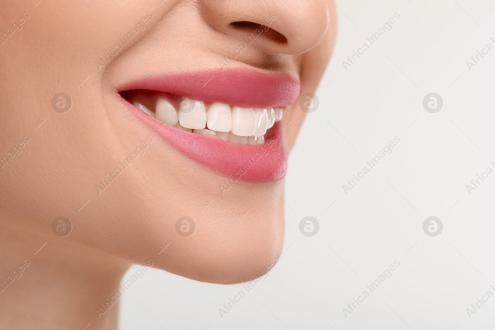 Photo of Young woman with beautiful smile on white background, closeup