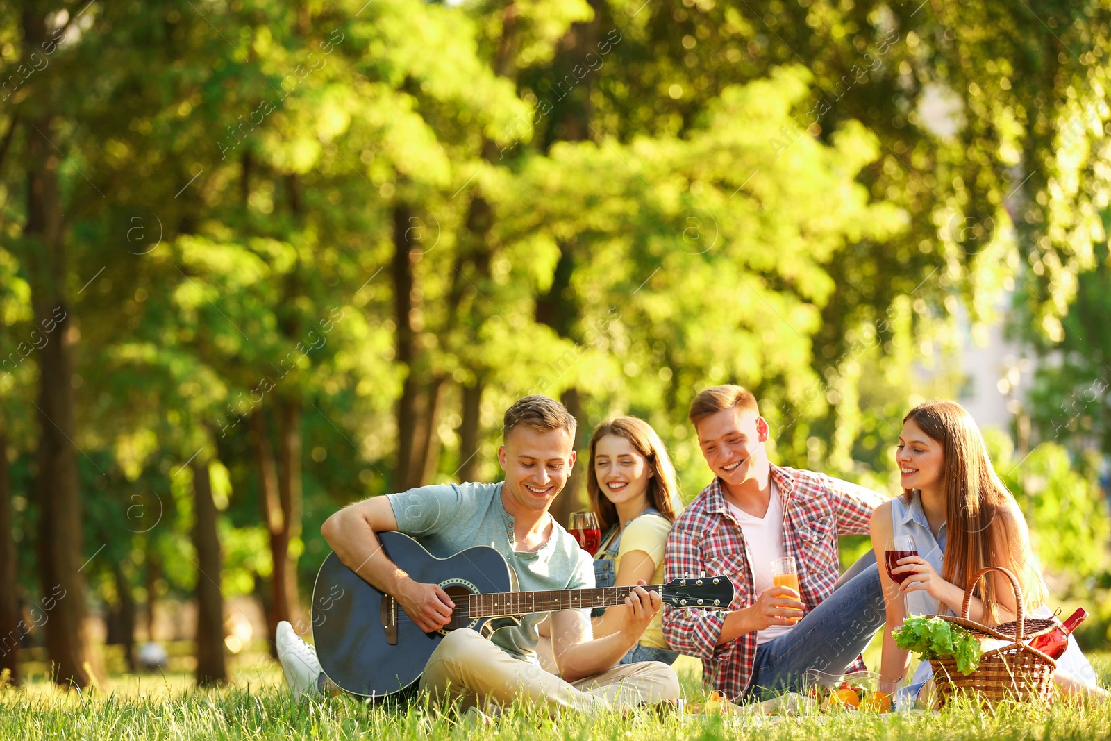 Photo of Young people enjoying picnic in park on summer day