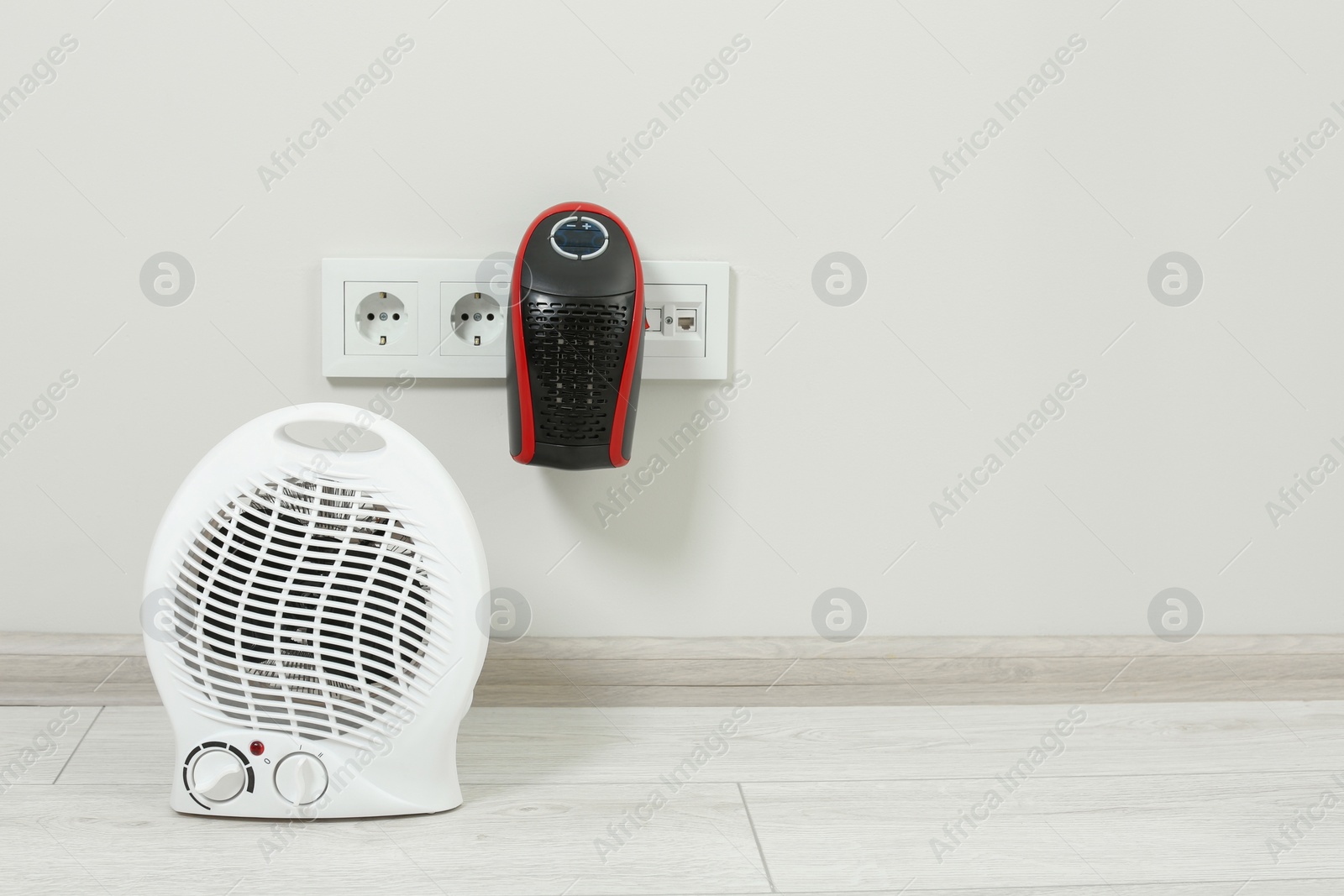 Photo of Modern electric compact and fan heaters indoors, space for text