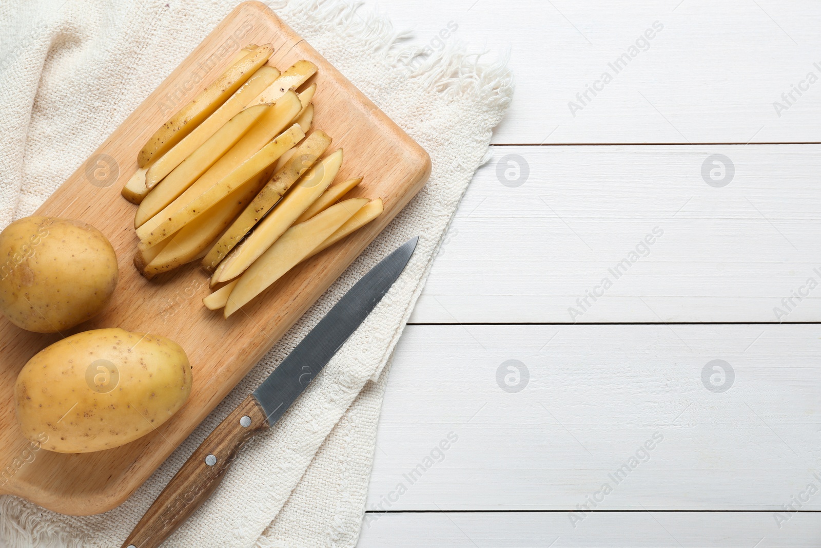 Photo of Potatoes and knife on white wooden table, top view with space for text. Cooking delicious french fries