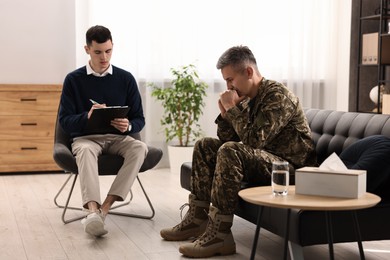 Professional psychotherapist working with military man in office