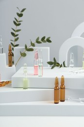 Stylish presentation of different skincare ampoules on white background