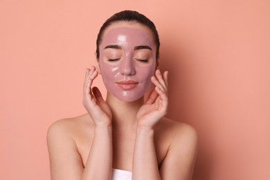 Woman with pomegranate face mask on pale coral background