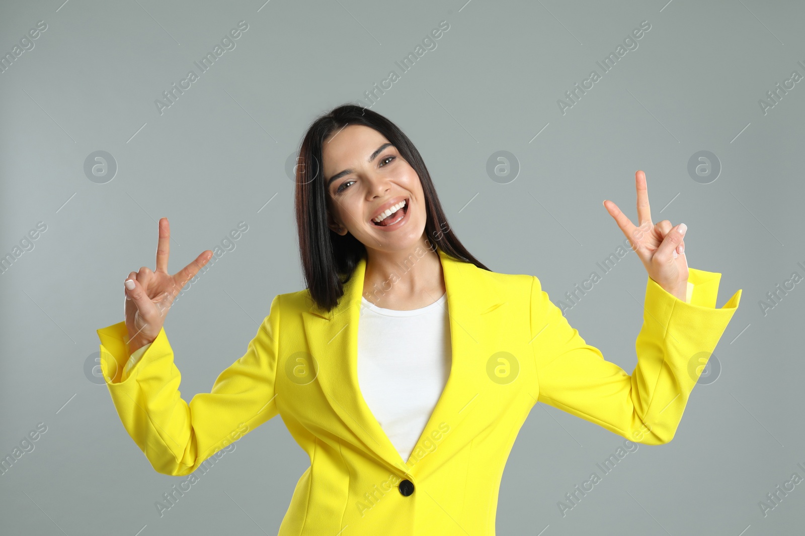 Photo of Woman showing number four with her hands on grey background