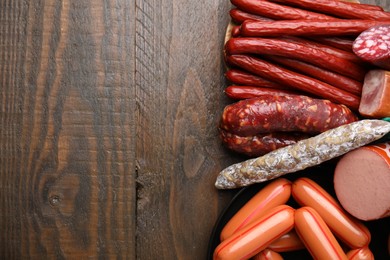 Photo of Different types of sausages on wooden table, flat lay. Space for text