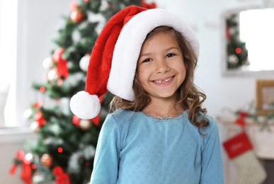 Cute little child in Santa hat at home. Christmas celebration