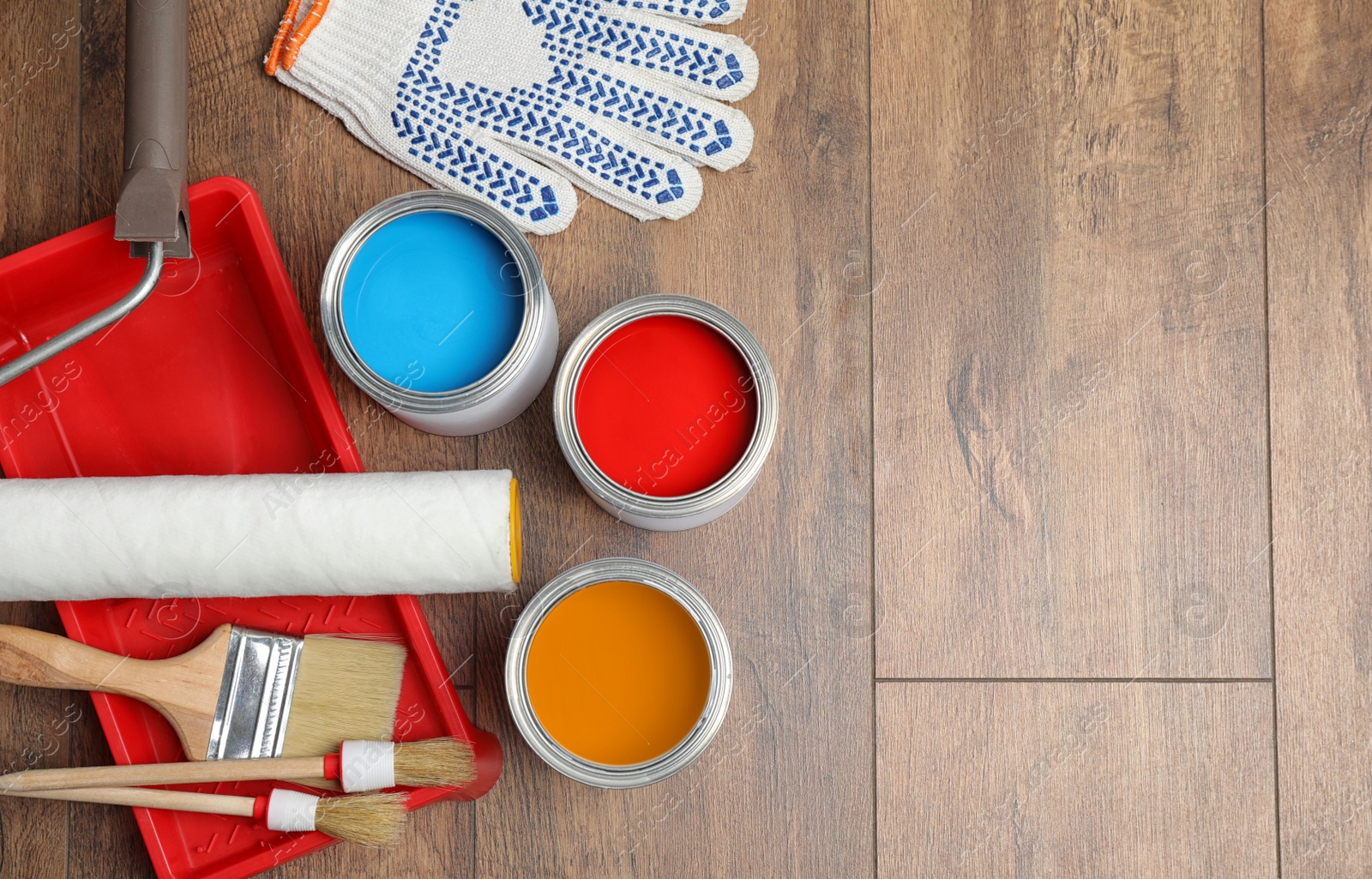 Photo of Flat lay composition with cans of paint and brushes on wooden background. Space for text