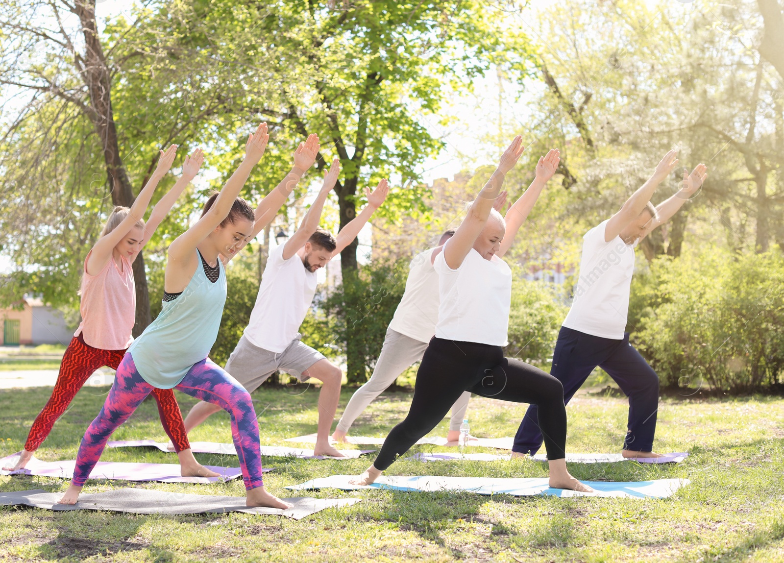 Photo of Group of people practicing yoga in park on sunny day