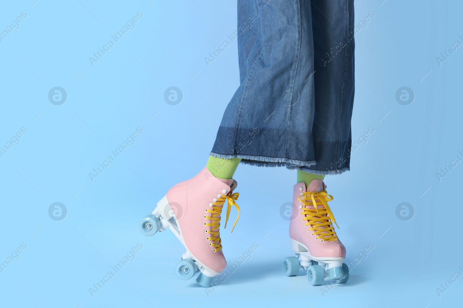 Photo of Woman with vintage roller skates on color background, closeup. Space for text