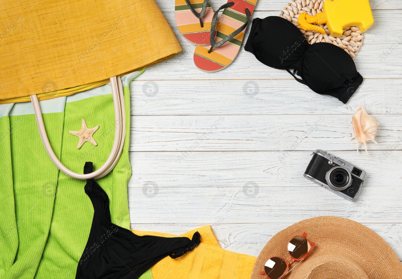 Photo of Flat lay composition with swimsuit and beach accessories on wooden background. Space for text