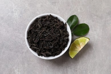 Photo of Dry bergamot tea leaves and fresh fruit on light grey table, flat lay