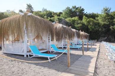 Photo of Sandy beach with loungers and huts at resort