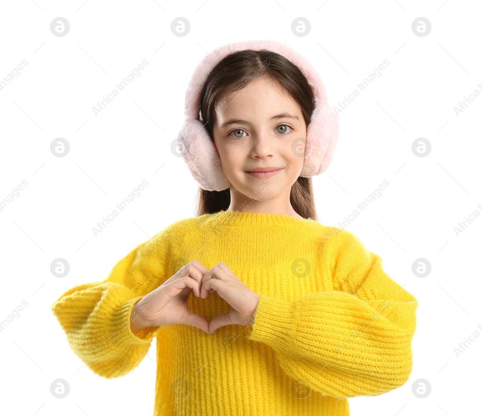 Photo of Cute girl in stylish earmuffs making heart with hands on white background