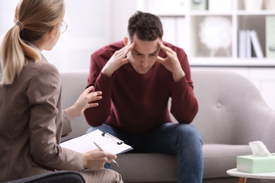 Photo of Psychotherapist working with young man in office