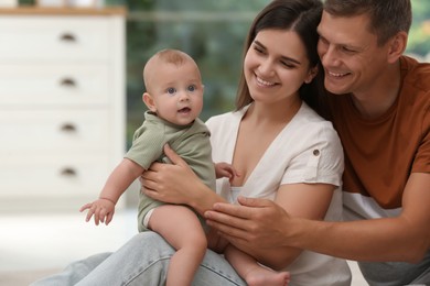 Portrait of happy family with their cute baby at home