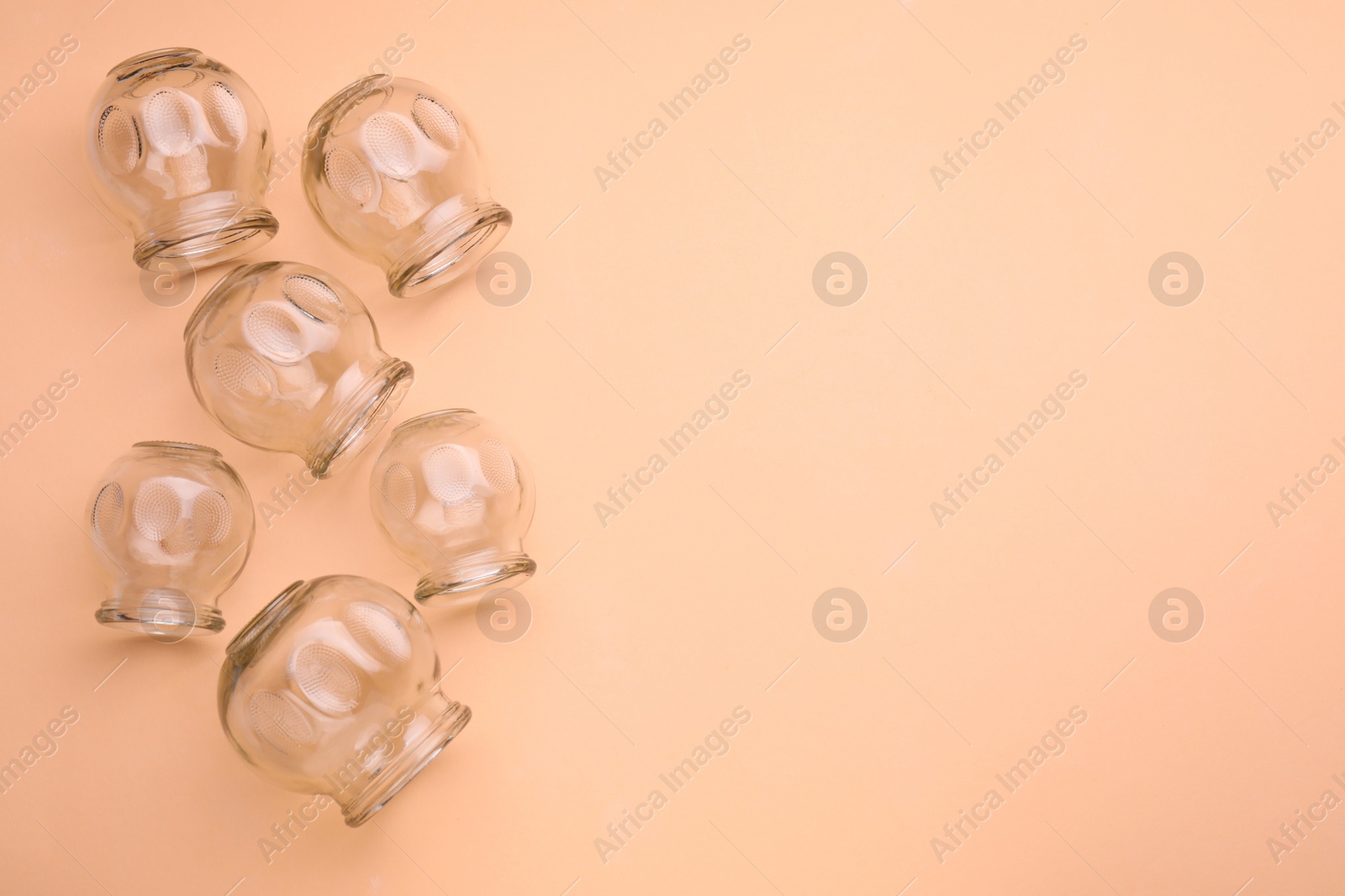 Photo of Glass cups on light coral background, flat lay and space for text. Cupping therapy