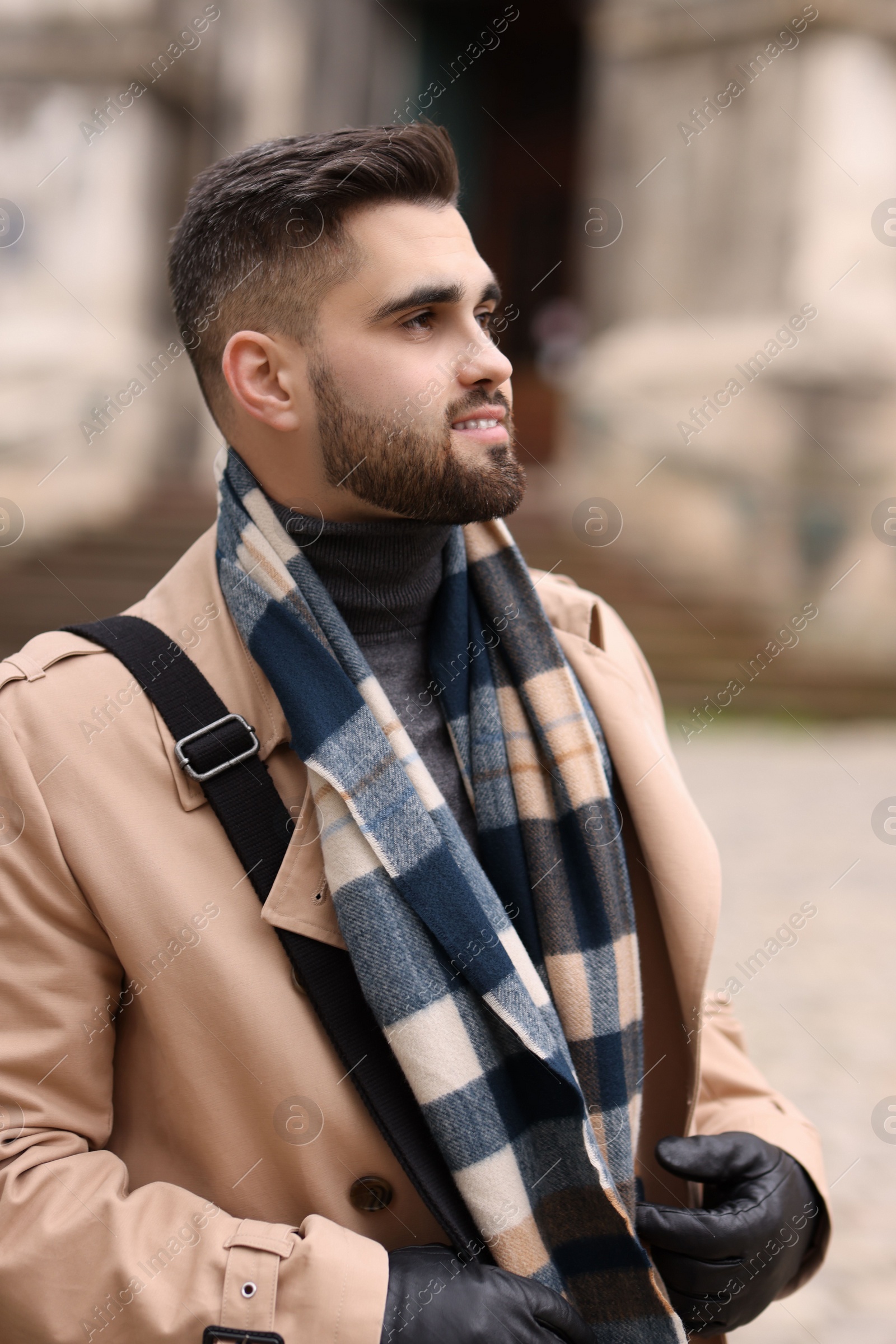 Photo of Handsome man in warm scarf on city street