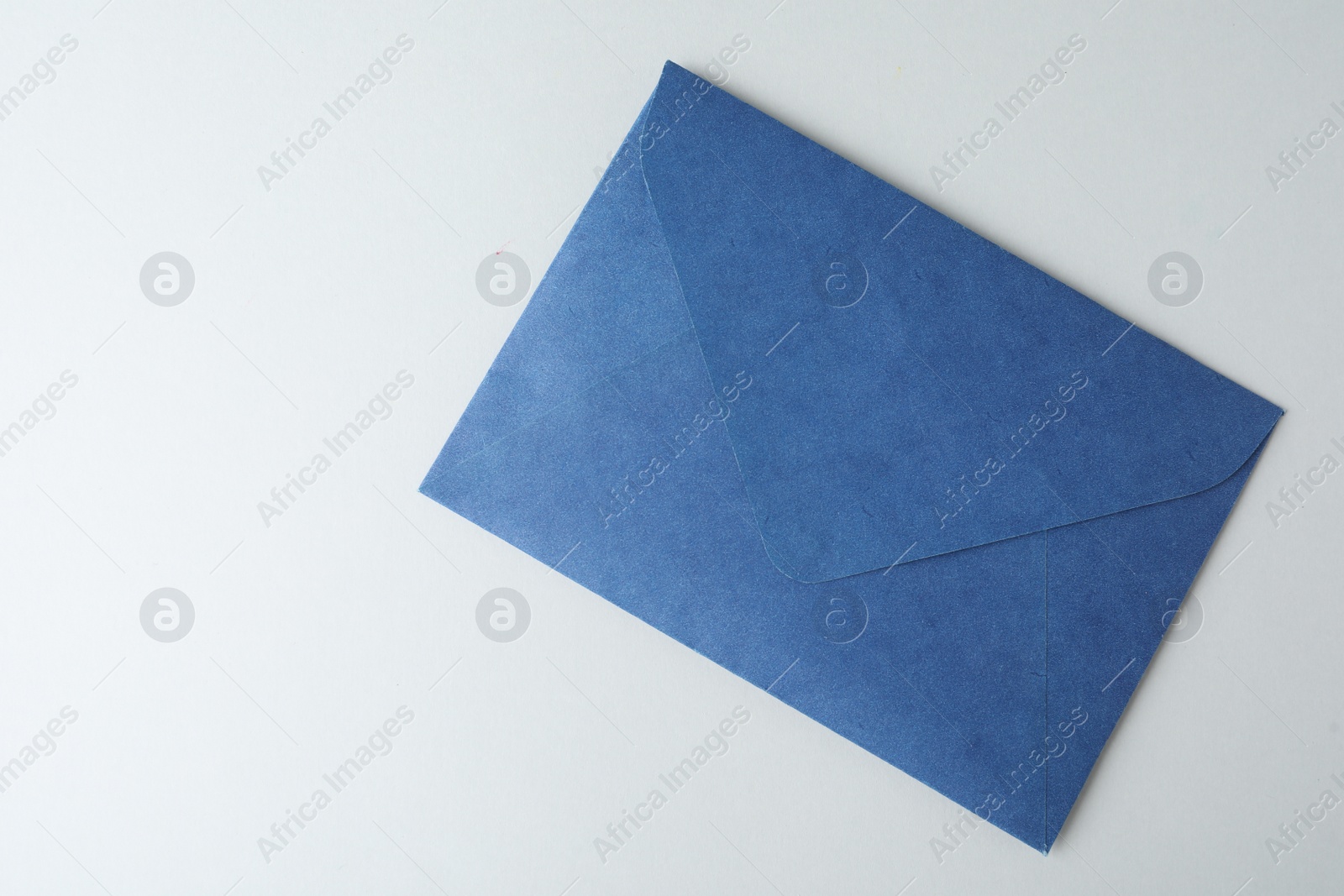 Photo of Blue paper envelope on light background, top view